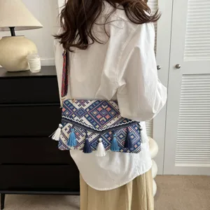 Detailed shot of bohemian ethnic style envelope shoulder bag with colorful woven tassels.