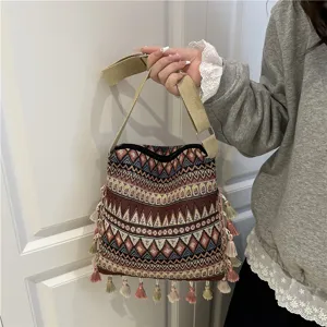 Ethnic style woven shoulder bag with bohemian geometric pattern and tassel details.