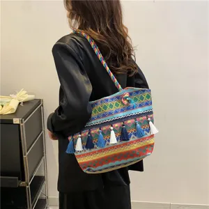 Close-up view of the ethnic style woven shoulder tote bag with colorful tassels and detailed design.