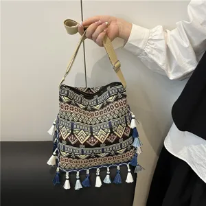Ethnic style canvas shoulder bag with geometric woven patterns and elegant tassels for women.