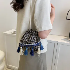 Bohemian tassel bucket bag detail, featuring woven texture and stylish blue white fringe.