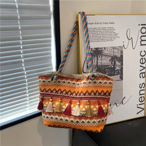 Detailed view of the ethnic woven straw tote bag with colorful braided handles and tassels.