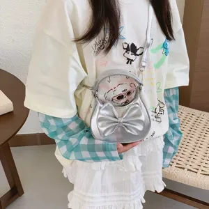 Children's silver metallic handbag featuring a large bow, cute mini crossbody bag style for girls.