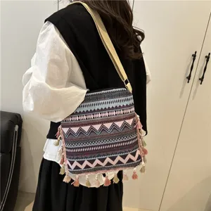 Ethnic style retro shoulder bag detail showing geometric pattern and tassels hanging nicely.