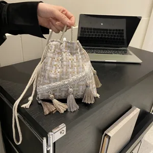 Detailed view of women's ethnic fringe bucket bag, woven tweed shoulder crossbody purse.