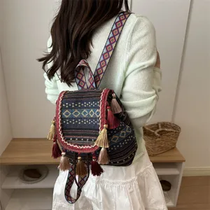 Ethnic style casual backpack detail featuring vibrant diamond print, woven straps, and playful tassels.
