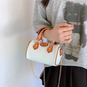 Kids mini barrel handbag with gold chain strap, white PU leather and brown trim details.