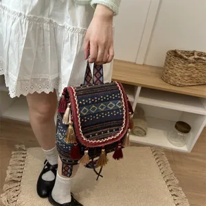 Bohemian style women mini backpack detail with ethnic pattern, tassels and geometric prints.