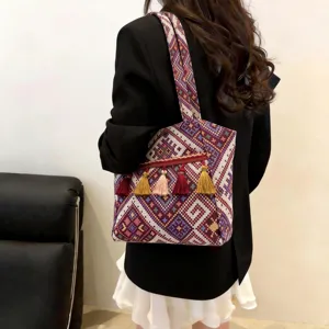 Detailed shot of ethnic style woven tote bag with colorful tassels, casual shoulder bag.