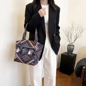 Ethnic style woven tote bag detail showing geometric pattern and tassel accessories for women.
