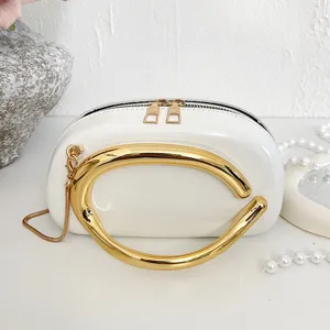 Elegant white structured crossbody bag featuring a statement gold-tone metal handle and chain.