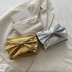 Metallic bow clutch bag for women, stylish evening party purse with shiny pleated design.