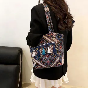 Ethnic woven tote bag detail showing colorful geometric patterns and delicate hanging tassels.