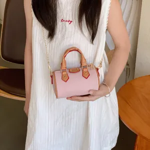 Mini pink barrel shoulder bag for kids, stylish chain strap handbag, cute children fashion accessory.