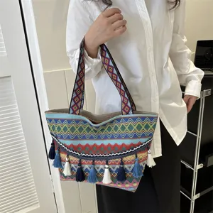 Ethnic style woven tote bag with colorful geometric patterns and elegant tassels.