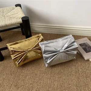 Metallic bow clutch bag for women, stylish evening handbag with large bow and spacious design.