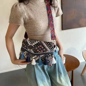 Ethnic style crossbody bag featuring colorful geometric strap and delicate tassel decorations.