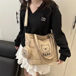 Detailed shot of a casual canvas tote bag with cute bear print and matching mini pouch.