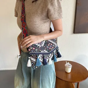 Ethnic woven crossbody bag for women with colorful strap and stylish tassel fringe design.