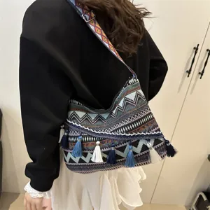 Bohemian ethnic style canvas shoulder bag with geometric stripes and tassels for women.
