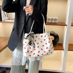 Vista dettagliata della borsa tote in velluto a coste bianco con stampa fragola e manici.