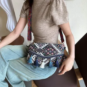 Ethnic style woven envelope shoulder bag with colorful strap and tassel details in daily scene.