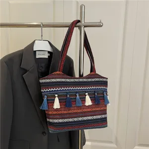 Ethnic style colorful woven tote bag detail showing rich geometric patterns and hanging tassels.
