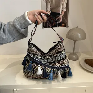 Boho ethnic style striped canvas shoulder bag with tassel details and large capacity design.