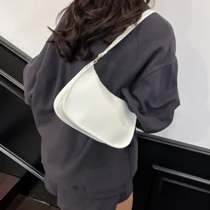 Minimalist white underarm shoulder bag detail showing sleek curved design and strap.