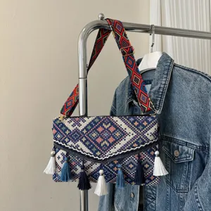 Bohemian style woven crossbody bag detail, featuring colorful geometric patterns and elegant tassels.
