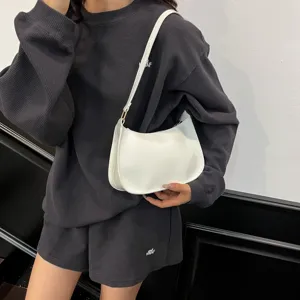 White minimalist underarm shoulder bag detail, stylish women accessory showing texture.