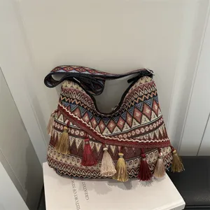 Boho ethnic woven shoulder handbag detail featuring colorful geometric patterns and tassels.