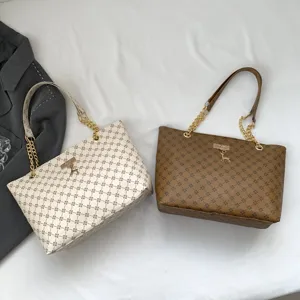 Large capacity tote bag with monogram pattern, gold chain strap and elegant deer pendant detail.