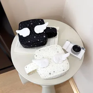 Detailed view of star print cosmetic bag with angel wings, cute aesthetic storage clutch.