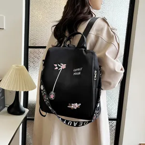 Detailed view of women black casual backpack featuring embroidery flowers and stylish strap.