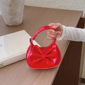 Red kids mini handbag with cute bow detail, perfect stylish accessory for little girls detail shot.