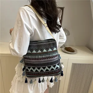 Ethnic style woven shoulder bag for women with geometric patterns and tassel fringe details.