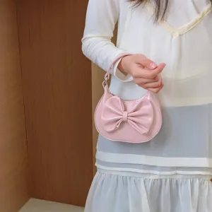 Detailed view of cute pink children mini handbag featuring large sweet bow decoration and handle.