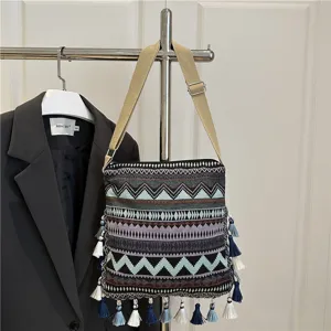 Ethnic woven shoulder bag with tassels and geometric patterns, stylish crossbody bag.