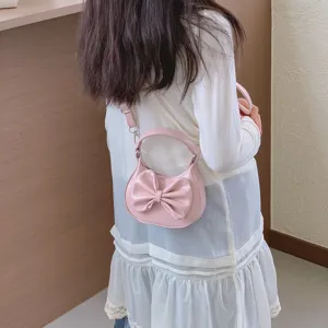 Pink mini children handbag detail showing the cute bow design and shoulder strap style.