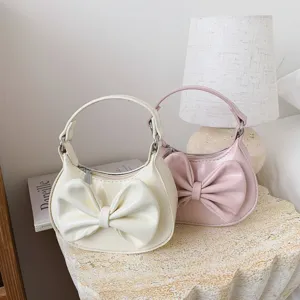 Detailed view of cute kids bow handbag, solid color shoulder bag in cozy bedroom lifestyle setup.