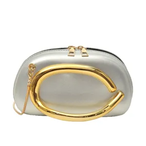 Stylish silver women crossbody bag with luxury gold metallic ring handle and chain strap.