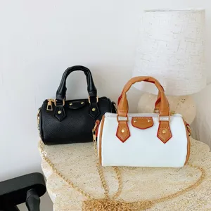 Kids mini pillow handbag detail featuring stylish black and white crossbody bags with gold chains.