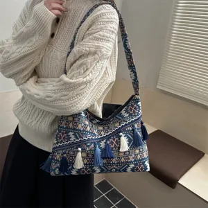 Vista detallada del bolso de hombro étnico para mujer con borlas coloridas y patrón.