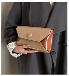 Detailed close-up view of colorblock envelope clutch bag, elegant design with snap button.