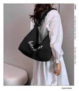 Detail view of the casual nylon tote bag with shoulder strap and letter print design.