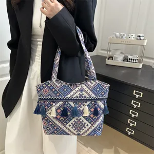 Detail view of the ethnic embroidered tote bag with stylish tassels and geometric woven fabric.