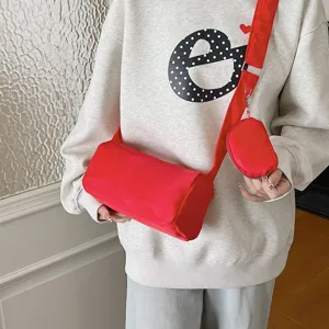 Red cylindrical crossbody bag with small coin pouch, casual solid color shoulder bag.
