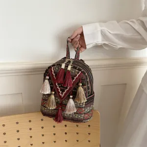 Ethnic style woven small backpack with tassel details, perfect for casual daily use.