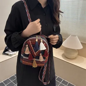 Close-up detail of the boho ethnic mini backpack, featuring colorful tassels and patterns.